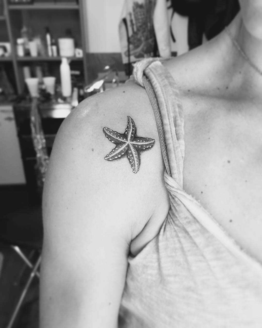 Fine line starfish tattoo behind the ear